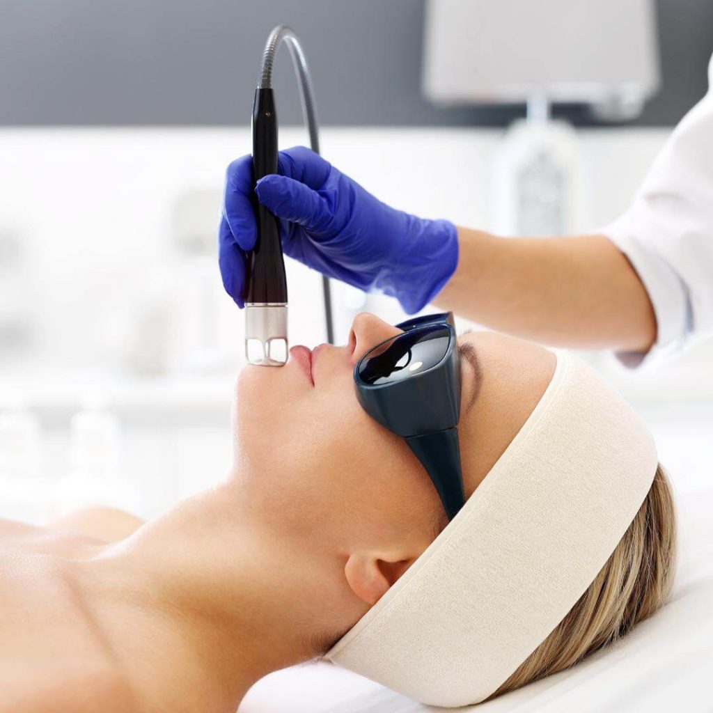 Aesthetician performs Laser Genesis on client's face.