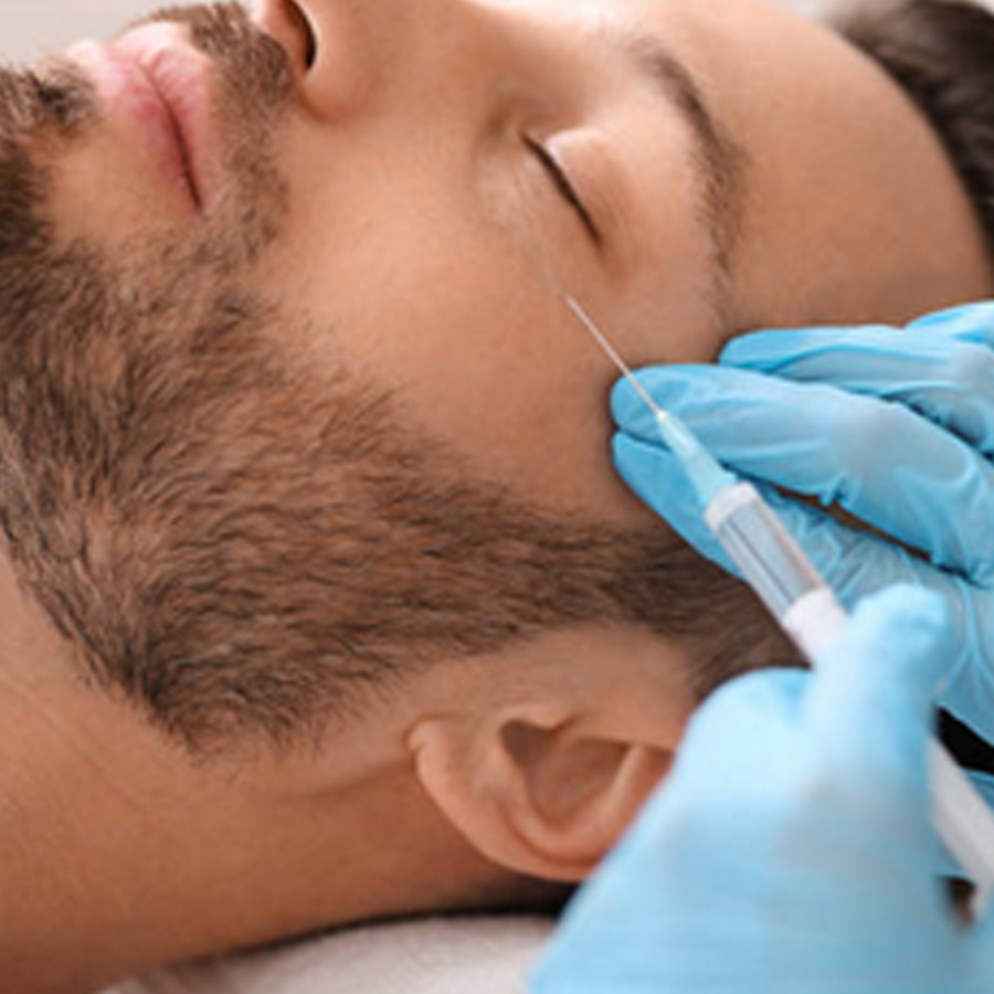 Aesthetic nurse injects filler into a man's tear trough.