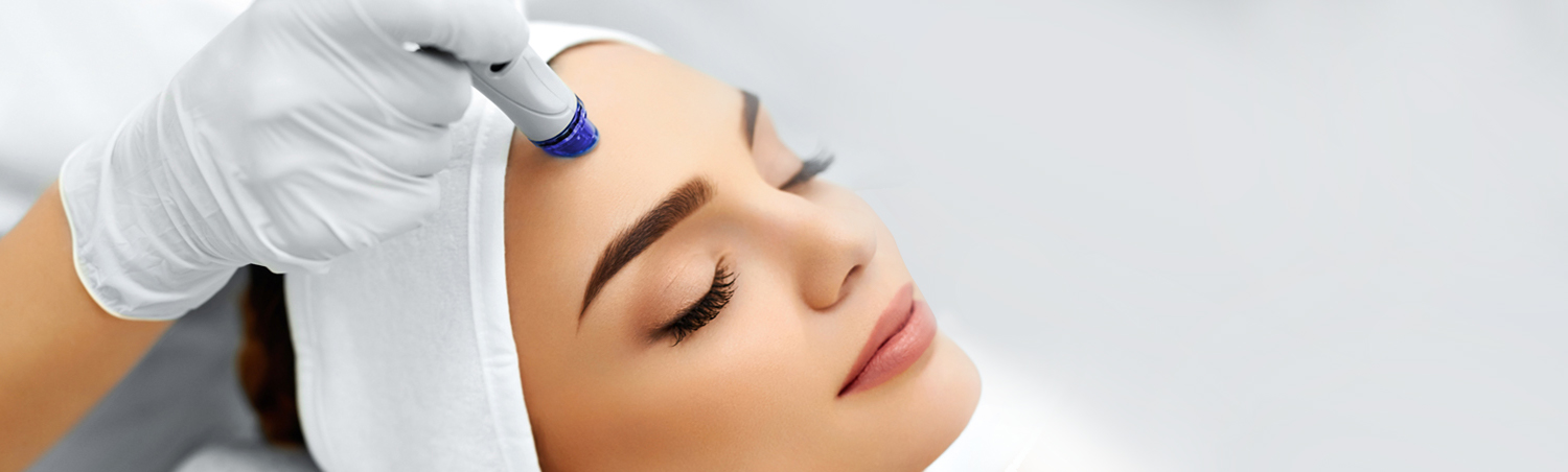 Aesthetician performs a Hydrafacial on client's face.